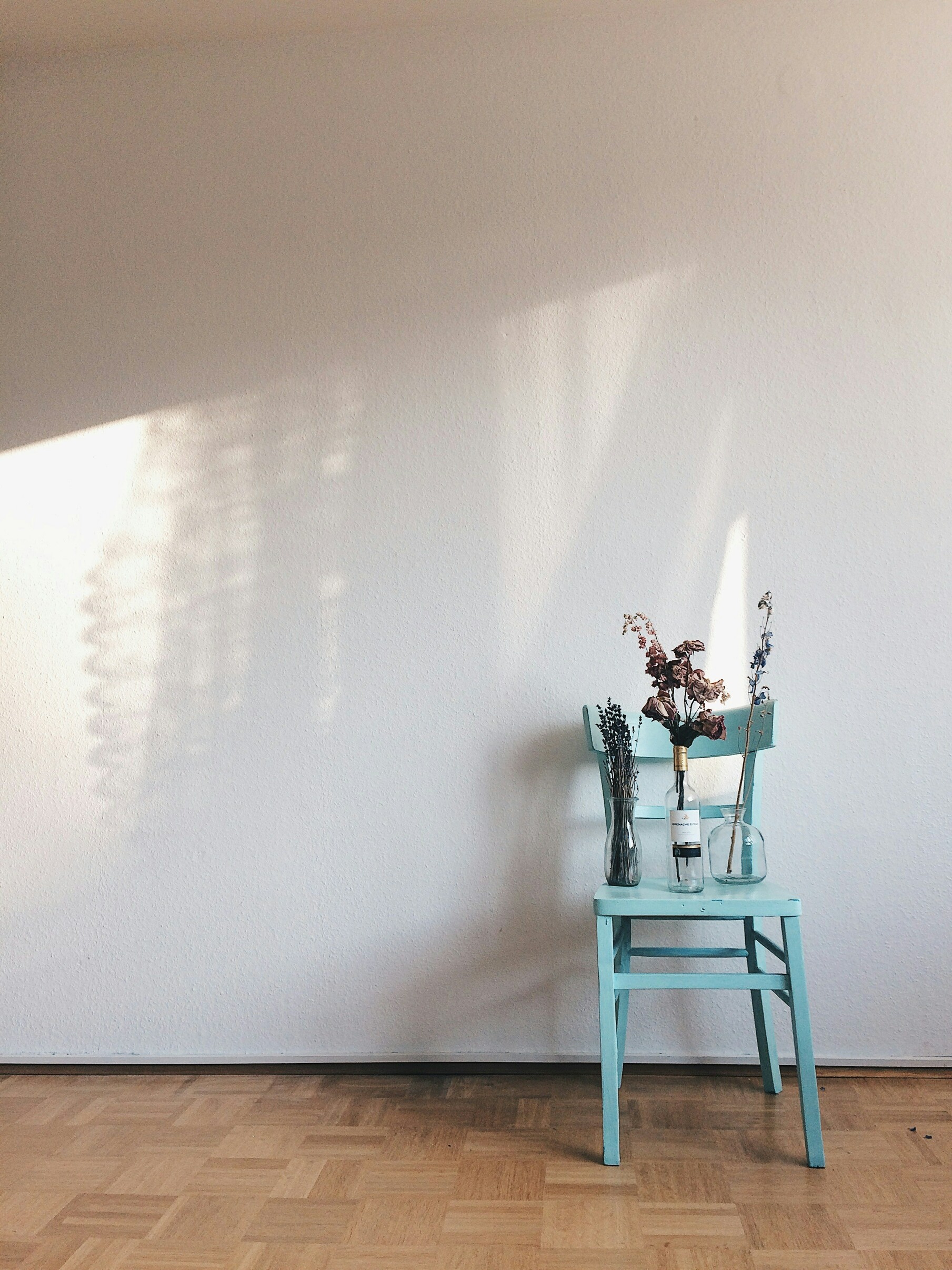 A blue chair sitting in front of a white wall